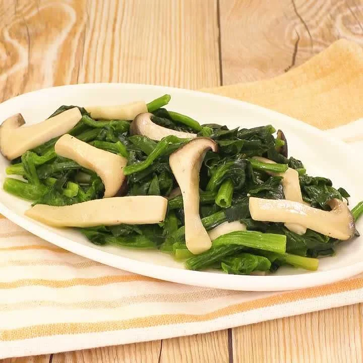 Rau xanh xào cùng nấm trên đĩa trắng