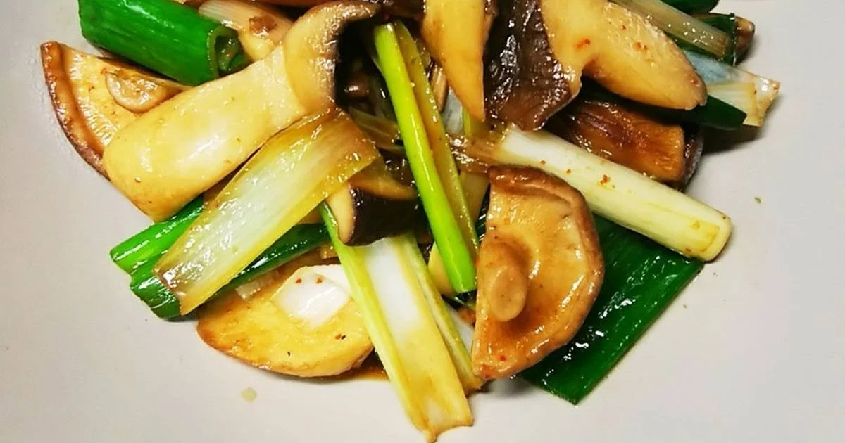 Món nấm xào cùng hành lá và rau củ trong đĩa trắng